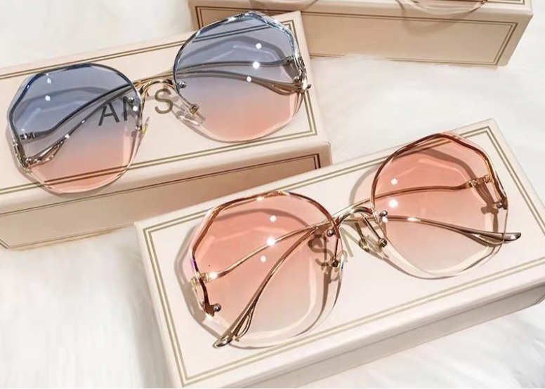 Three pairs of sunglasses on their respective boxes with a soft white background